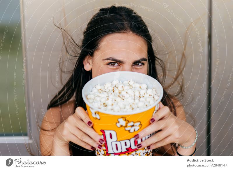 Lovely girl posing with popcorn Woman youngster Popcorn Laughter Joy Town Cheerful Bucket Playful Hipster Style Clothing Portrait photograph covering face