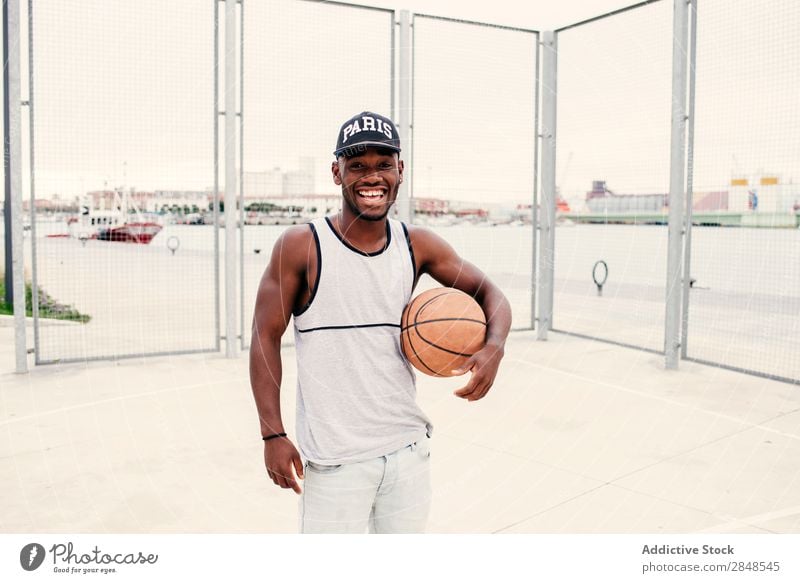 Black man with basketball Man Basketball Ball outstretching street ball Self-confident Sports ground Town Masculine Street sportsman Style Posture