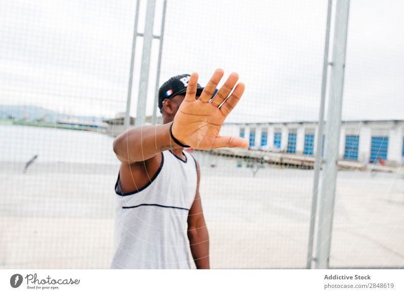 Man covering face on sports ground Sports ground Basketball Posture Outstretched Palm of the hand Self-confident Town sportsman Masculine Skyline Hand