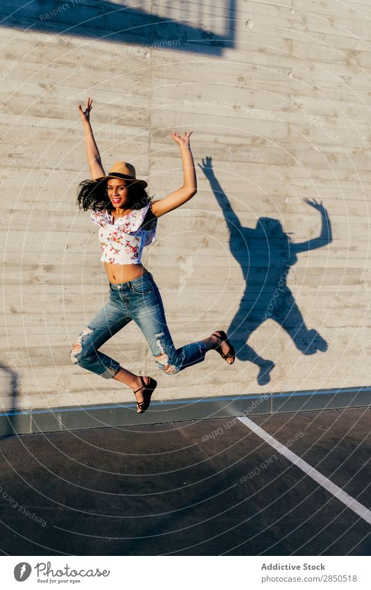 Woman jumping with hands up pretty Street Walking Easygoing Hat Hands up! Jump Joy Fashion Beautiful Youth (Young adults) Town Girl Style City
