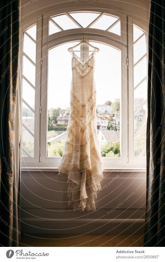 Wedding dress hanging on window a Royalty Free Stock Photo from