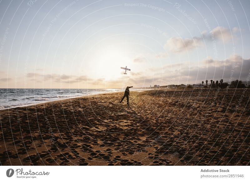 An unrecognizable man on a beach throwing the toy plane Human being Airplane Playing Throw Story Beach Happy Joy Toys Lifestyle Dream Childish Man Evening Coast