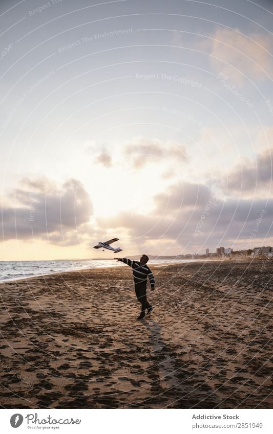 Man on a beach throwing the toy plane Human being Airplane Playing Throw Story Beach Happy Joy Toys Lifestyle Dream Childish Evening Coast Ocean Water Intellect