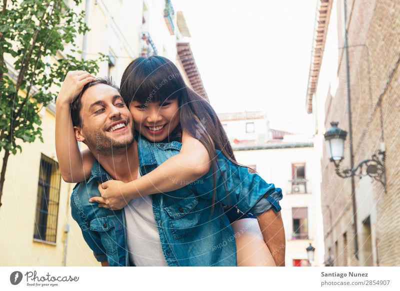 Happy loving couple. Happy young man piggybacking his girlfriend. asian Beautiful boyfriend Recklessness Cheerful Chinese City Couple Family & Relations