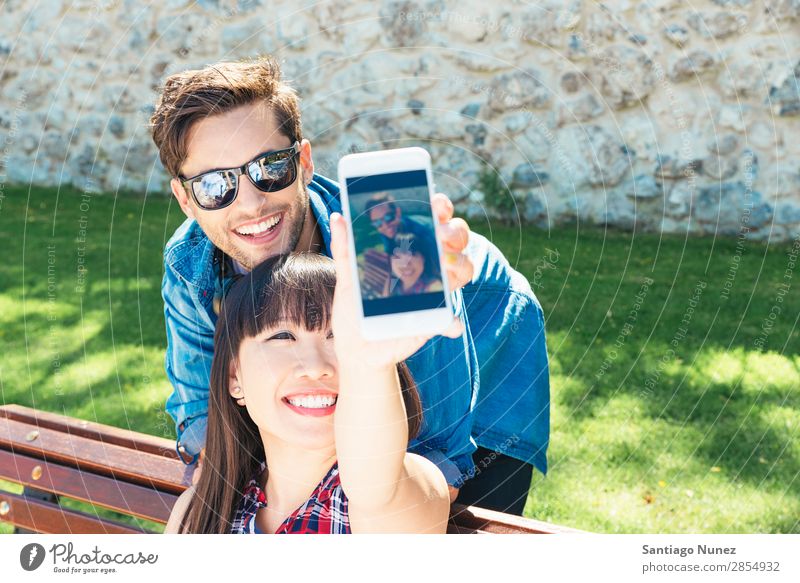 Young happy couple using smart phone in the park asian Beautiful boyfriend Easygoing Solar cell Cellphone Chinese Communication Connection Copy Space Couple