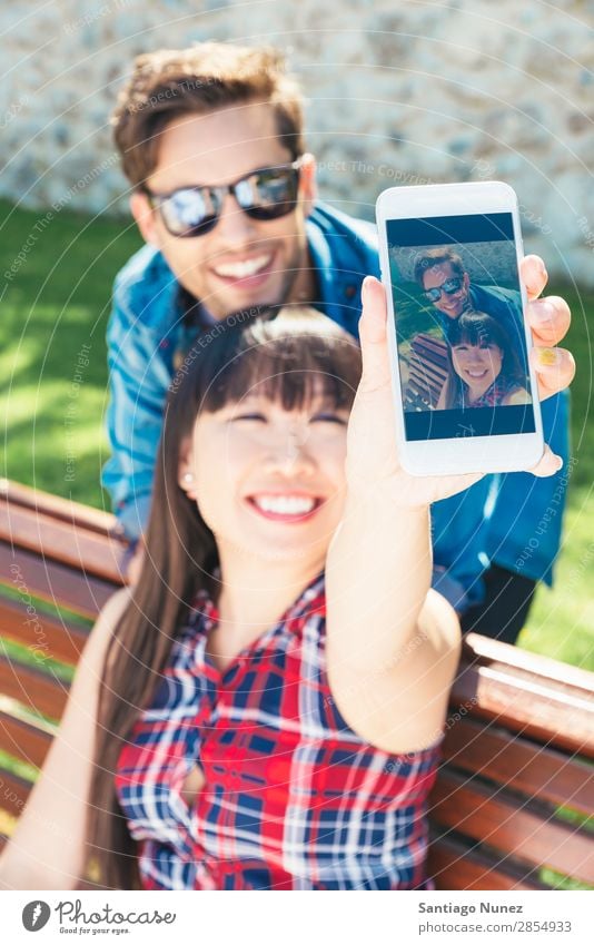 Young happy couple using smart phone sitting in the park asian Beautiful boyfriend Easygoing Solar cell Cellphone Chinese Communication Connection Copy Space