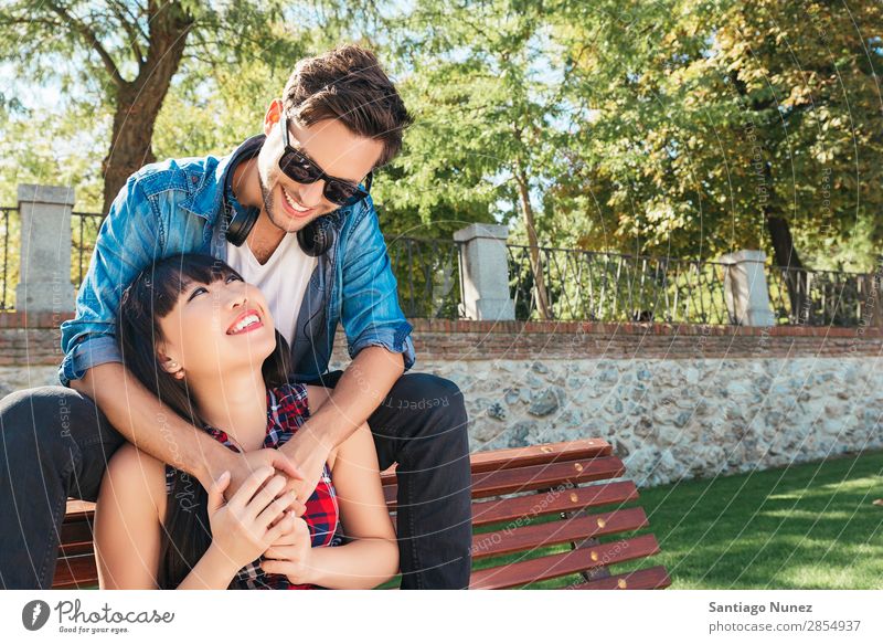 Young happy couple using smart phone sitting in the park asian Beautiful boyfriend Easygoing Solar cell Cellphone Chinese Communication Connection Copy Space