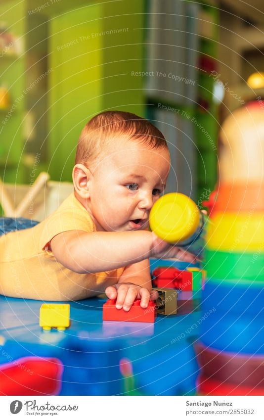 Happy baby playing with toy blocks in the kindergarten. Baby Playing childcare Kindergarten School Toys Toddler Boy (child) Small Child Considerate Story Cute