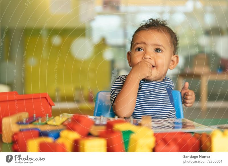 Happy baby playing with toy blocks. Baby Playing childcare Kindergarten School Toys Toddler Girl Small Child Smiling Considerate Cute Joy Preschool Education