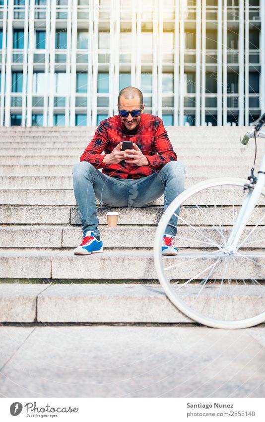 Young man with mobile phone and fixed gear bicycle. Mobile Man Bicycle fixie Telephone Hipster Lifestyle Stand Cycling City Building Solar cell Town Human being