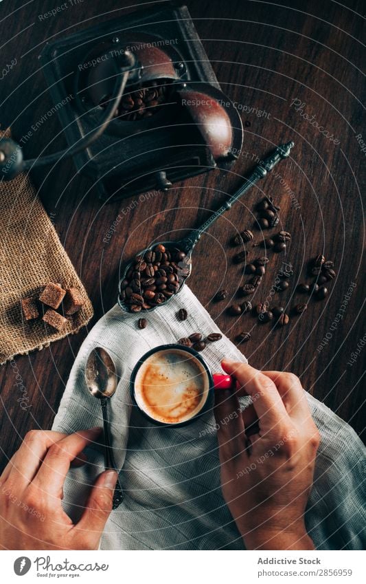 Closeup of hands takes a cup of espresso Coffee Espresso Black Fresh Strong Beans coffee beans coffee mill Antique Old Sugar Dice Brown Napkin Aromatic arabic