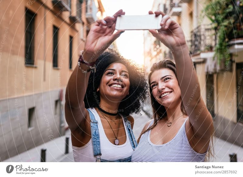 Beautiful women taking a self portrait in the Street. Woman Friendship Youth (Young adults) Happy Summer Human being Joy Mobile PDA Telephone Solar cell