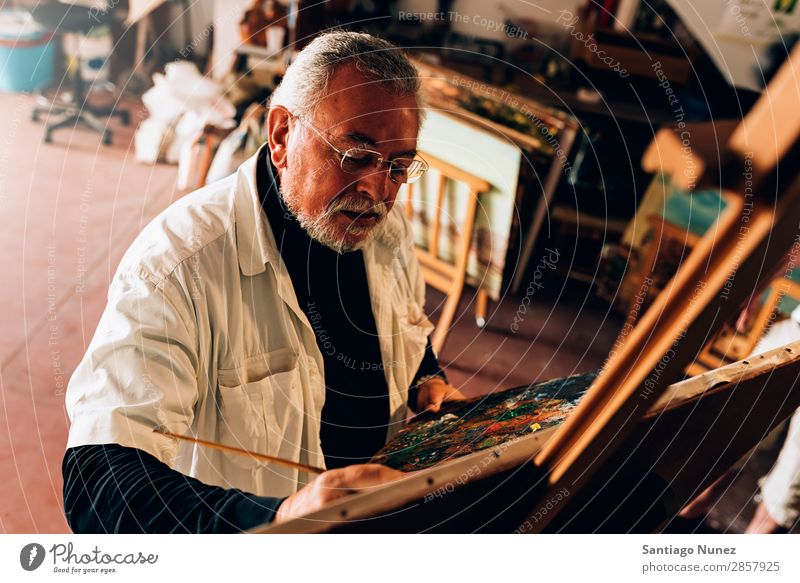 Old man artist painting oils in his studio. Man Adults Beard Artist Painter concentrated Painting and drawing (object) Paintbrush Brush Easel Canvas Concentrate