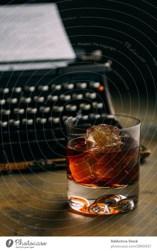 Glass of whiskey and a retro typewriter Alcoholic drinks Amber Analog Antique Beverage Bourbon Brandy Character Classic Cognac Creativity Drinking Gold Ice