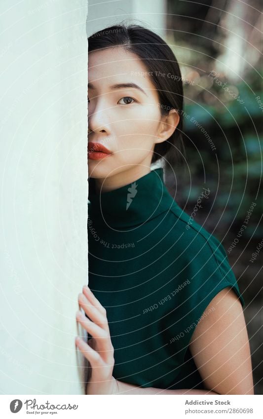 Asian woman leaning on wall Woman Youth (Young adults) Attractive Dress Green asian Japanese Wall (building) Lean Looking into the camera hiding Beautiful