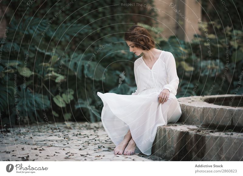 Attractive woman at pond in park Woman Youth (Young adults) Dress White Sit Pond Concrete Forest Park Looking into the camera Beautiful Beauty Photography