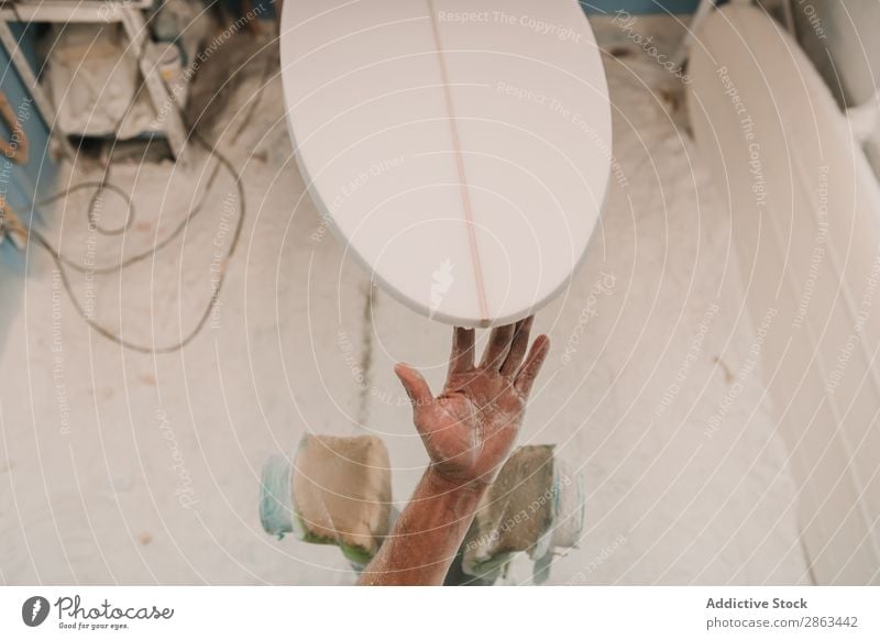 Man in respirator polishing surf board in workshop Surfboard Workshop carpentry Sandpaper Workplace Breather Carpenter Tool Weapon Wood Construction