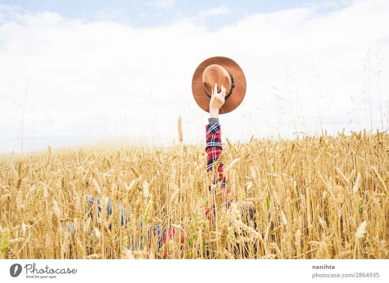 Hand holding a cowboy hat over a field of wheat Organic produce Lifestyle Style Design Joy Happy Beautiful Wellness Well-being Contentment Relaxation Freedom