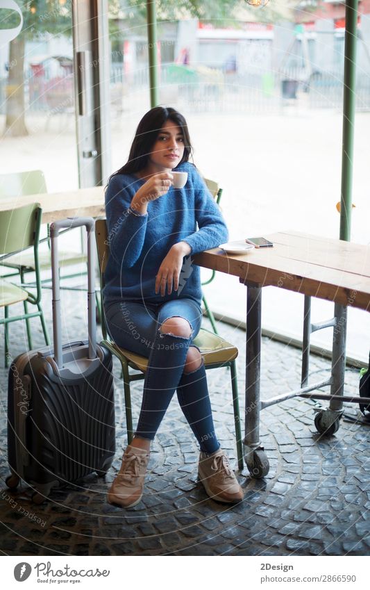 Beautiful young woman sitting while drinking a coffee in a cafe Drinking Coffee Tea Lifestyle Style Relaxation Vacation & Travel Trip Work and employment