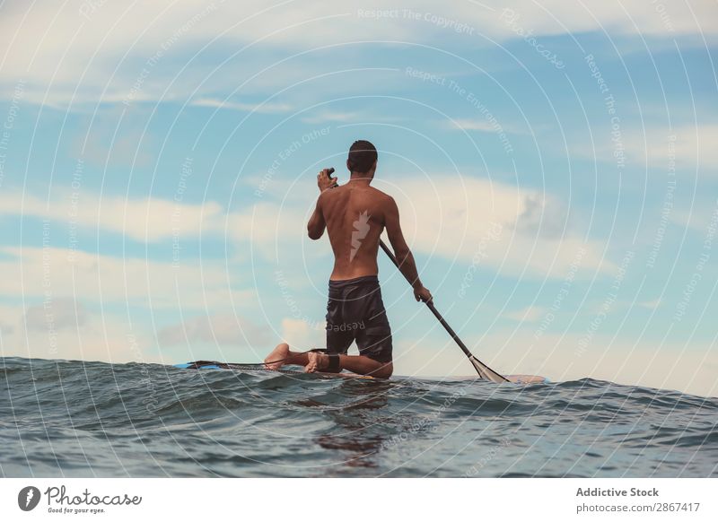 Man with paddle on surf board waving on water Surfboard Water Surface Sports Bali Indonesia Paddle Sky Ocean Heaven Blue Paddling Ripple Landscape