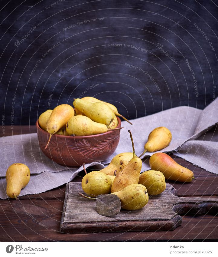 ripe yellow pears in a brown clay bowl Fruit Nutrition Vegetarian diet Diet Bowl Table Nature Autumn Wood Old Eating Fresh Delicious Natural Above Juicy Brown