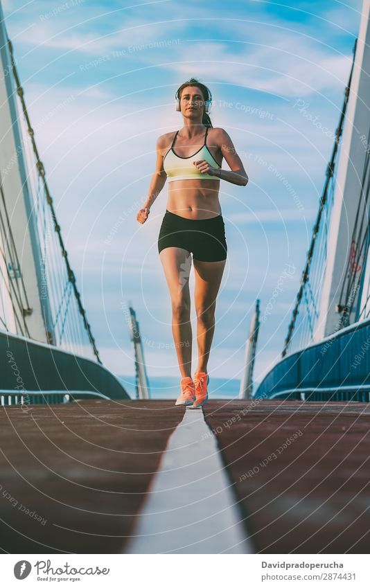 Young fit blonde woman running on the bridge Woman Running Practice Fitness work out Lifestyle Movement Action Jogging Bridge Vertical Athletic Healthy