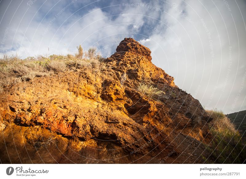 Iron hat Nature Landscape Plant Earth Sand Sky Clouds Summer Beautiful weather Grass Bushes Hill Rock Red Orange Rock formation Stone Minerals Colour photo