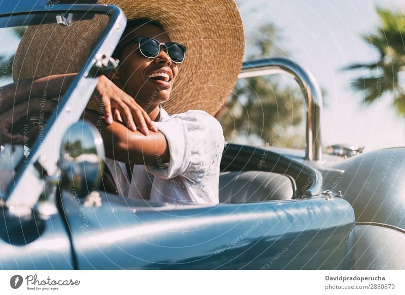 Black woman driving a vintage convertible car Woman Car Driving Ethnic Convertible Street Happy Classic Luxury Vintage Looking away Transport Cheerful Smiling