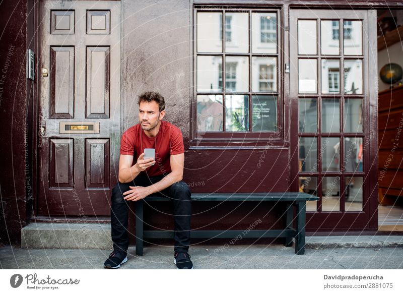 Man sitting in a bench on a beautiful maroon background Cellphone Caucasian Building Youth (Young adults) Architecture Technology Vintage Notting Hill decor