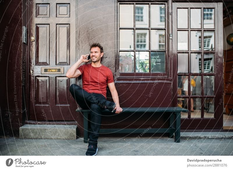 Man sitting in a bench on a beautiful maroon background Cellphone Caucasian Cheerful Building Youth (Young adults) Architecture Technology Vintage Smiling