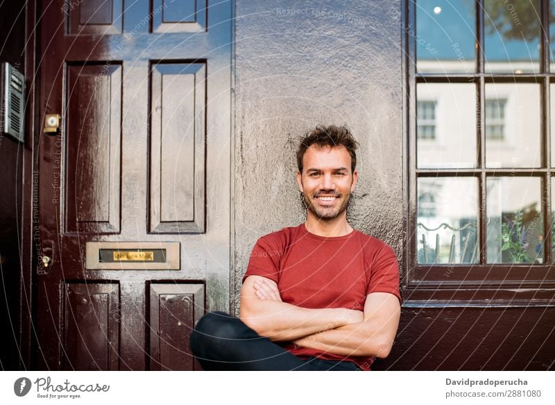 Man sitting in a bench on a beautiful maroon background Cheerful Caucasian Building Youth (Young adults) Happy Architecture Vintage Smiling Notting Hill decor