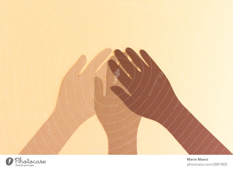 Together against racism // Three hands in different skin colours made of paper hold together Team Human being by hand Positive Brown Acceptance Trust Solidarity
