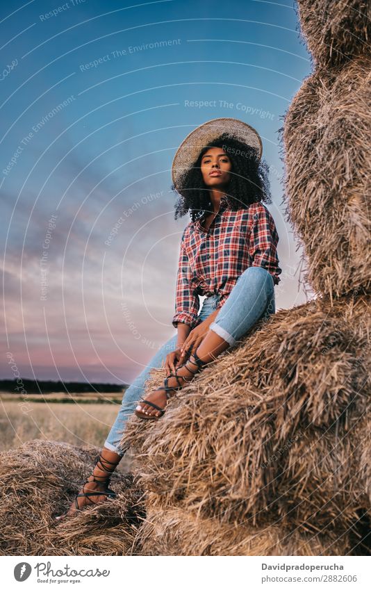 Happy black young woman sitting on a pile of hay Woman Farmer Hay Summer Ethnic Black African Landscape Nature Countries Sky Relaxation Lifestyle