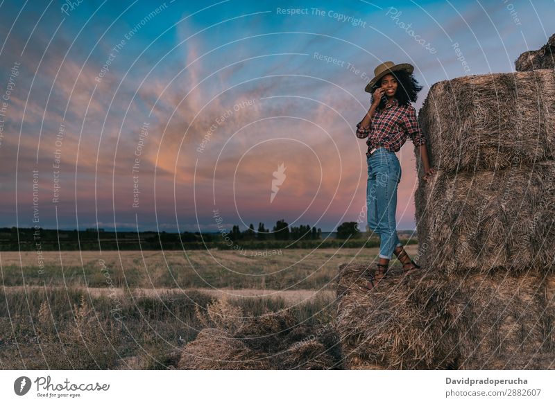 Happy black young woman standing on a pile of hay Woman Farmer Hay Summer Ethnic Black African Landscape Nature Countries Sky Relaxation Lifestyle