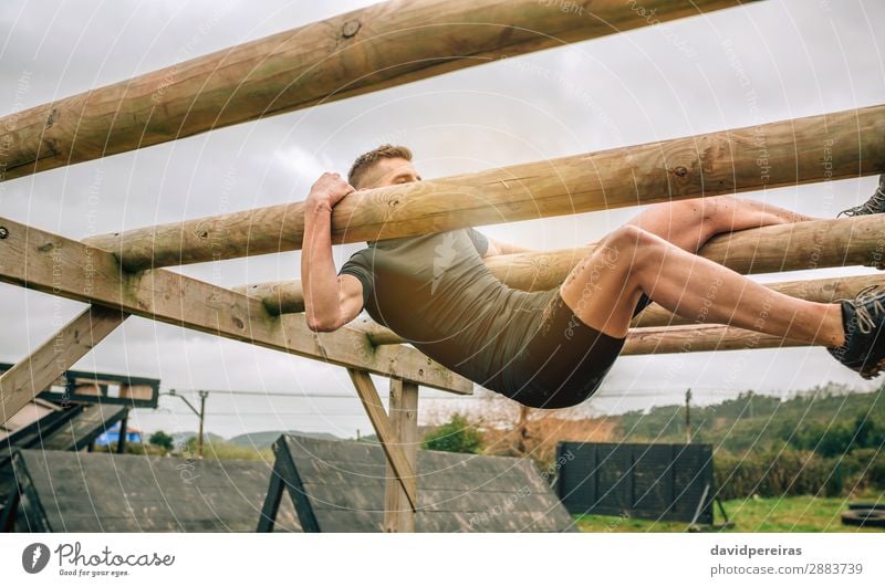 Man in obstacle course doing weaver obstacle Lifestyle Sports Human being Adults Wood Authentic Above Strong Power Effort Competition obstacle course race Hold