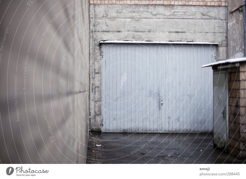 on the left Outskirts Industrial plant Factory Building Wall (barrier) Wall (building) Facade Garage door Cold Town Blue Gray Interior courtyard Colour photo
