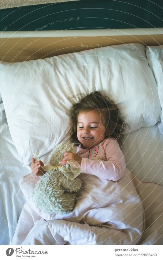 Little girl lying in a bed with teddy bear at the morning Happy Beautiful Playing Child Human being Woman Adults Toys Teddy bear Sleep Happiness Small Cute Bear