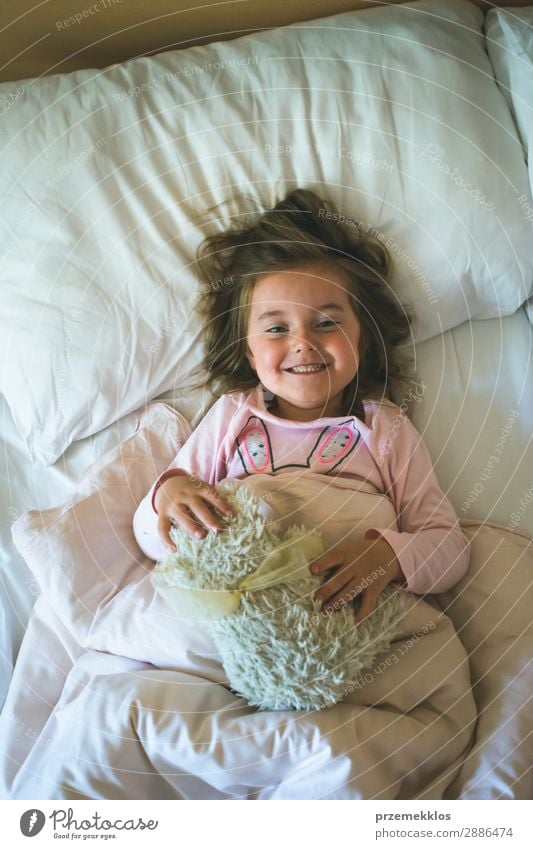 Little girl lying in a bed with teddy bear at the morning Happy Beautiful Child Human being Woman Adults Toys Teddy bear Sleep Happiness Small Cute Bear