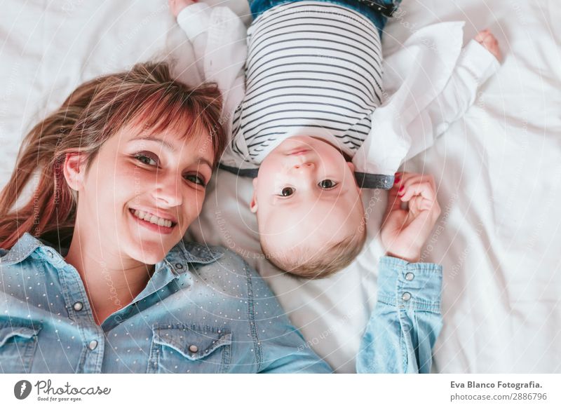happy young mother and her baby boy lying on bed and smiling Lifestyle Joy Happy Skin Lamp Bedroom Child Human being Masculine Feminine Baby Toddler Boy (child)