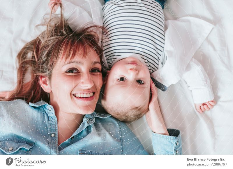 happy young mother and her baby boy lying on bed and smiling Lifestyle Joy Happy Skin Lamp Bedroom Child Human being Masculine Feminine Baby Toddler Boy (child)