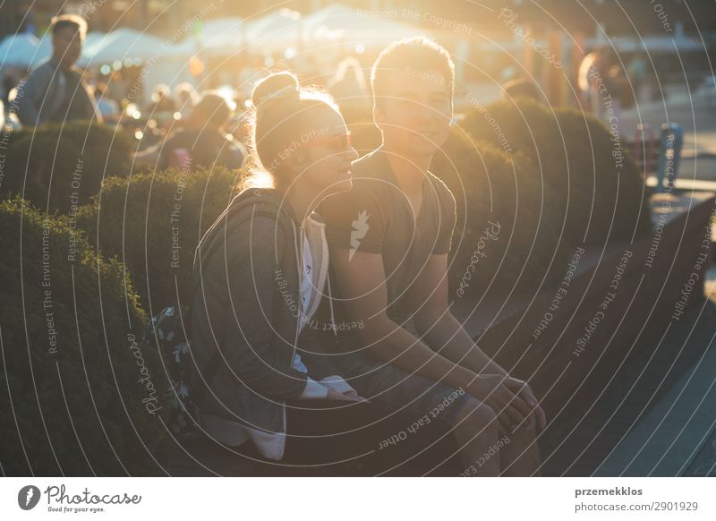 Couple of friends having fun, sitting in center of town Lifestyle Summer To talk Telephone Cellphone PDA Technology Woman Adults Man Friendship Media Town