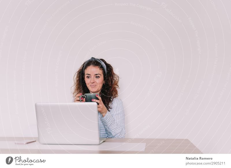 Brunette Woman Is Using Her Computer While Having A Coffee A