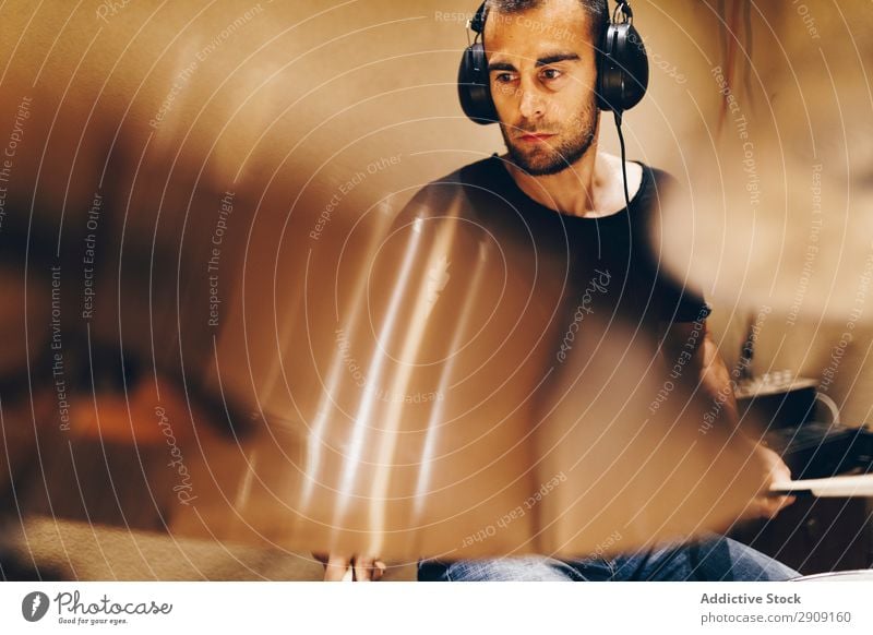 Man with headphones playing on drums Headphones Drum Playing Positive handsome Studio shot Music Professional Youth (Young adults) Drummer Equipment device