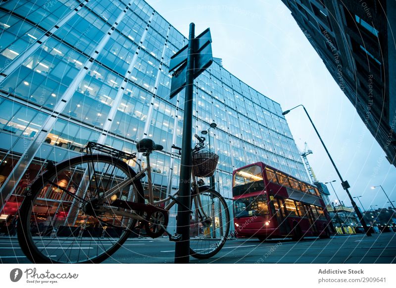 Bicycle and bus on city street double-decker Street City Bus Exterior London England Parked signpost Building Illuminate Evening Deserted Transport Vehicle Town
