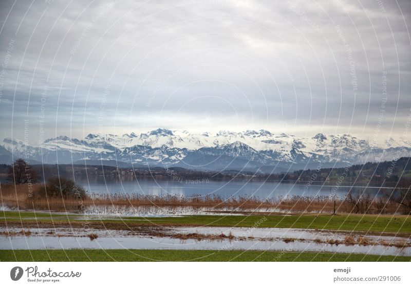 lakeside Environment Nature Landscape Sky Clouds Climate Bad weather Field Alps Mountain Peak Snowcapped peak Pond Lake Dark Natural Switzerland Deluge Winter