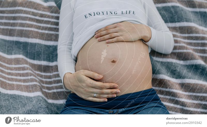 Pregnant belly lying on a blanket Lifestyle Relaxation Human being Baby Woman Adults Parents Mother Hand Aircraft Ring Touch Authentic Naked Expectation