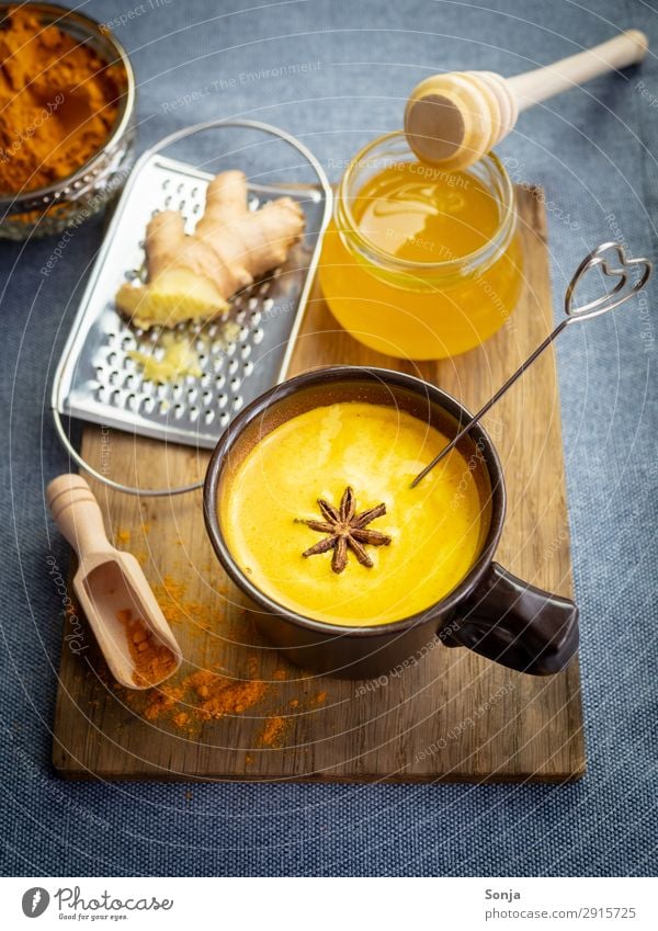 Golden milk with honey and ginger Food Dairy Products Herbs and spices Curcuma Honey Ginger Star aniseed Nutrition Beverage Hot drink Milk Cup Chopping board