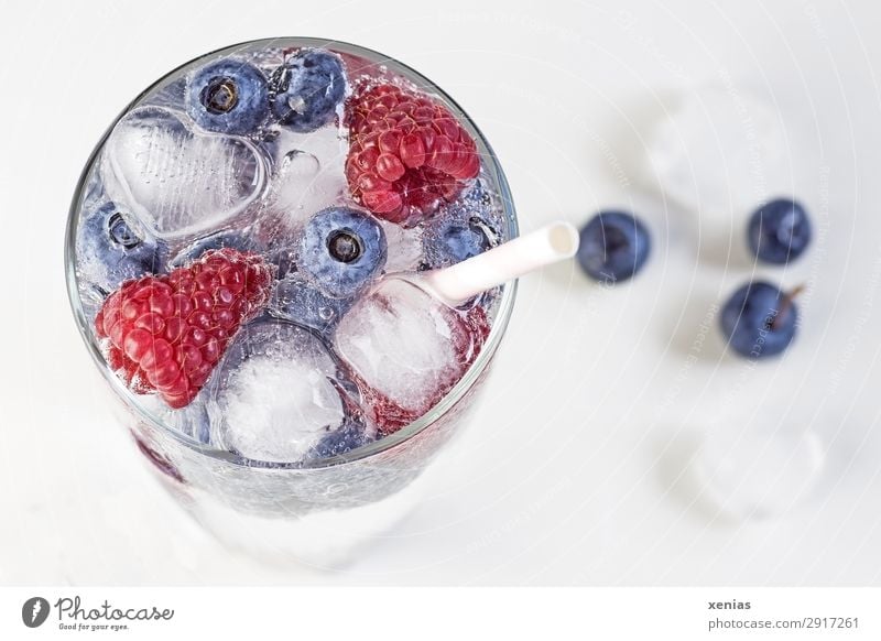 Iced soft drink in glass with berries, heart and ice cubes Beverage Cold drink Berries Fruit Raspberry Blueberry Ice cube Drinking water Glass Straw