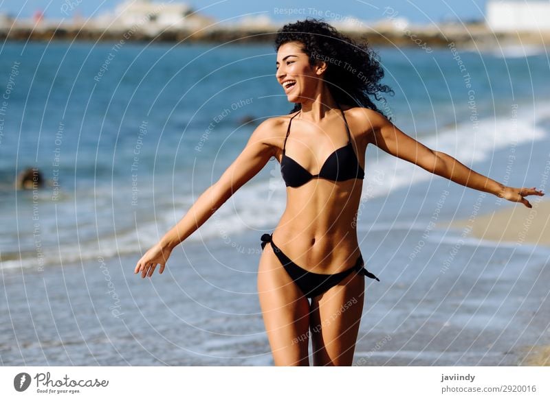 Young woman with beautiful body on a beach in a pink bikini Stock Photo