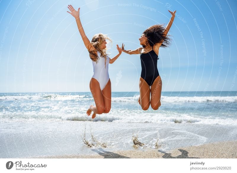 Two funny girls in swimsuit jumping on a tropical beach in summer. Lifestyle Joy Happy Beautiful Body Hair and hairstyles Leisure and hobbies Vacation & Travel